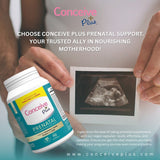 Person holding a container of Conceive Plus prenatal supplements with an ultrasound image in the background.