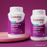 Two bottles of Conceive Plus Women's Fertility Support on a pink tray with a purple background.